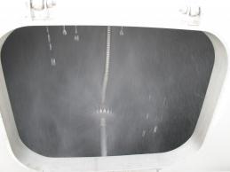 View inside the FERCHER spraytunnel through an opened inspection-panel, spray-nozzle and fine water-mist visible